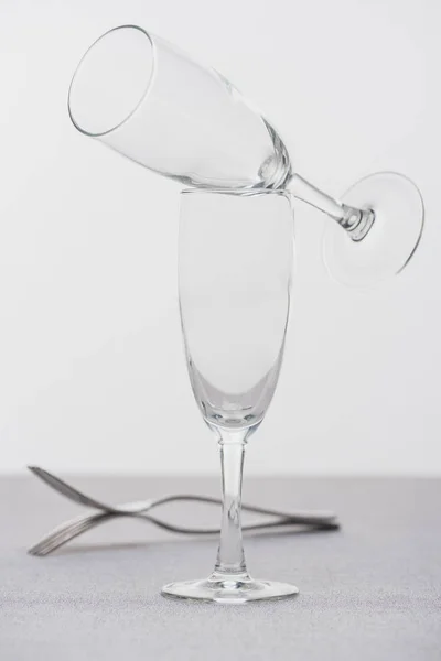 Selective focus of champagne glasses and forks on cloth isolated on grey — Stock Photo