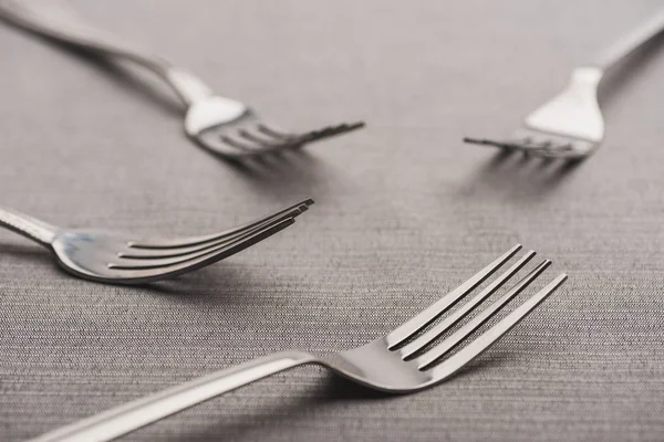 Foco seletivo de garfos brilhantes de toalha de mesa cinza — Fotografia de Stock