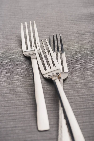 Selective focus of shiny forks on grey linen cloth — Stock Photo