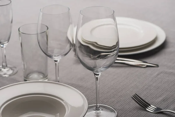 Vajilla con vasos en mantel gris - foto de stock