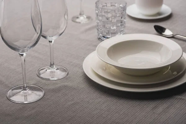 Servindo utensílios de mesa com copos de vinho em toalha de mesa cinza — Fotografia de Stock