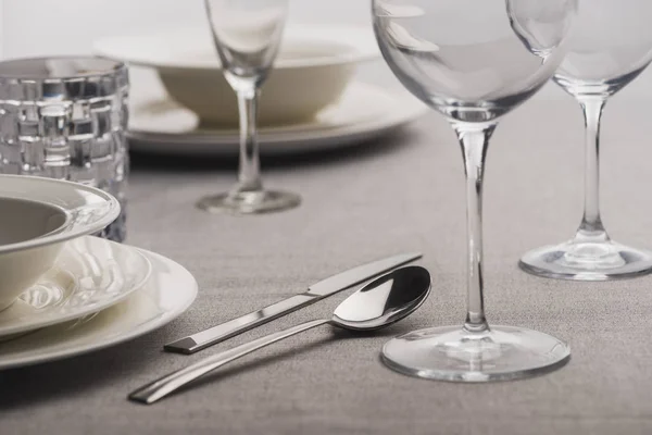 Selective focus of serving dishware on grey tablecloth — Stock Photo