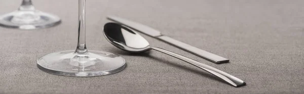 Colher e faca perto de copos de vinho na superfície cinza, tiro panorâmico — Fotografia de Stock