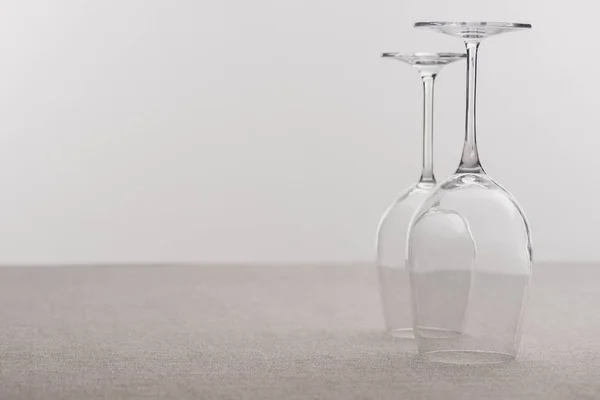 Umgekehrte Weingläser auf Tischdecke isoliert auf grau — Stockfoto