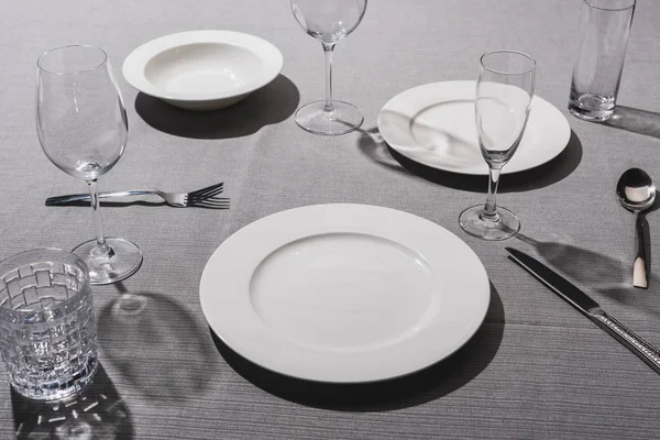 Vide vaisselle de service avec verres sur tissu gris — Photo de stock