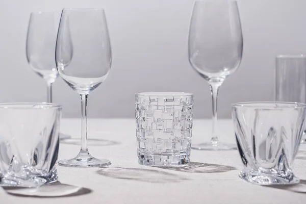 Empty glasses on white tablecloth isolated on grey — Stock Photo