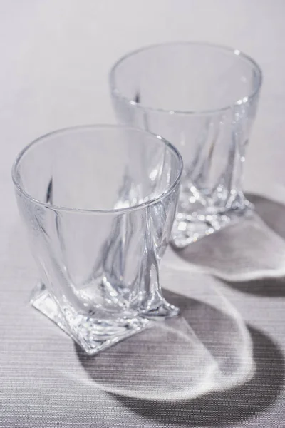 Bicchieri trasparenti con ombra su superficie grigia — Foto stock
