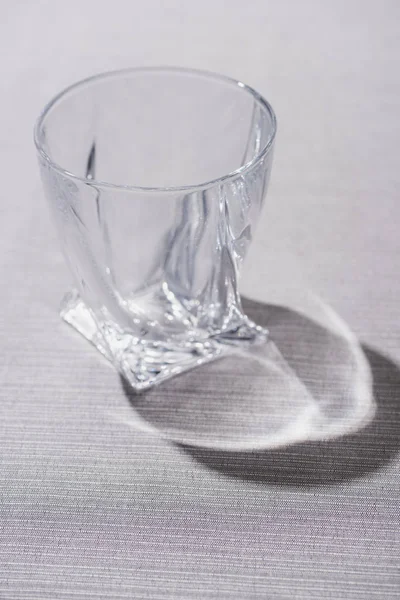 Clear glass with shadow on grey surface — Stock Photo