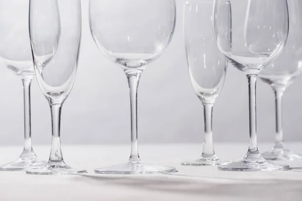 Shiny clear glasses on white surface isolated on grey — Stock Photo