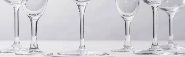 Панорамный снимок вина и бокалов шампанского на белой ткани, изолированной на сером — стоковое фото