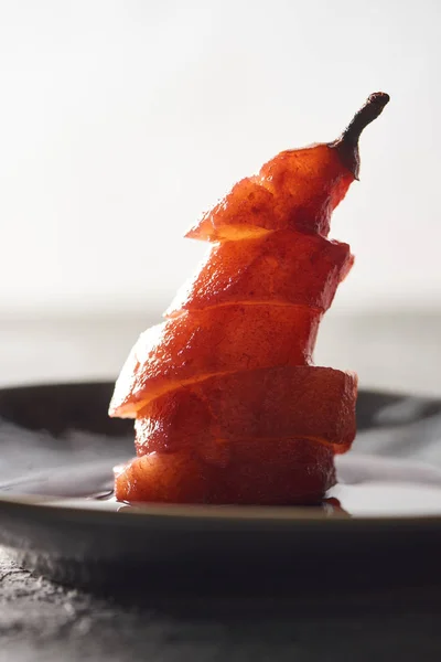 Close up view of delicious sliced pear in wine on plate — Stock Photo