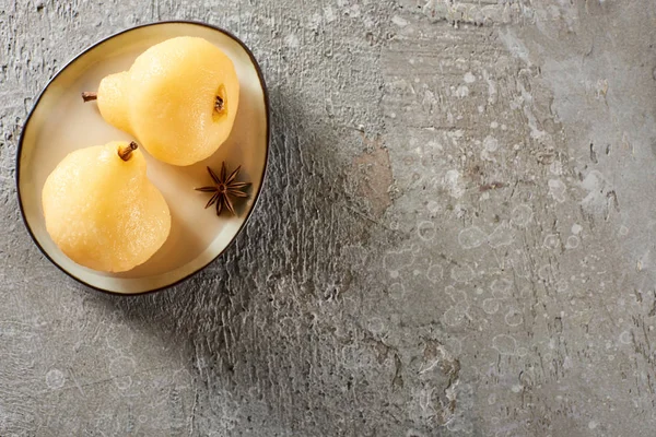 Top view of delicious pear in wine served with anise on plate on grey concrete surface — Stock Photo