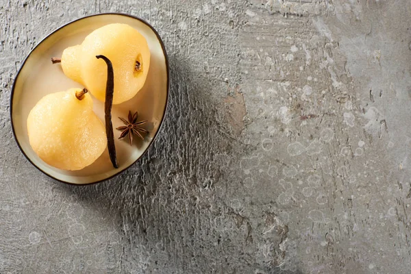 Top view of delicious pear in wine served with spice on plate on grey concrete surface — Stock Photo