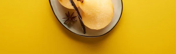 Top view of delicious pear in wine with anise on plate on yellow background, panoramic shot — Stock Photo