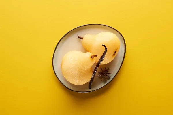 Top view of delicious pear in wine with anise on plate on yellow background — Stock Photo