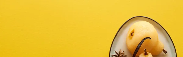 Top view of delicious pear in wine with anise on plate on yellow background, panoramic shot — Stock Photo