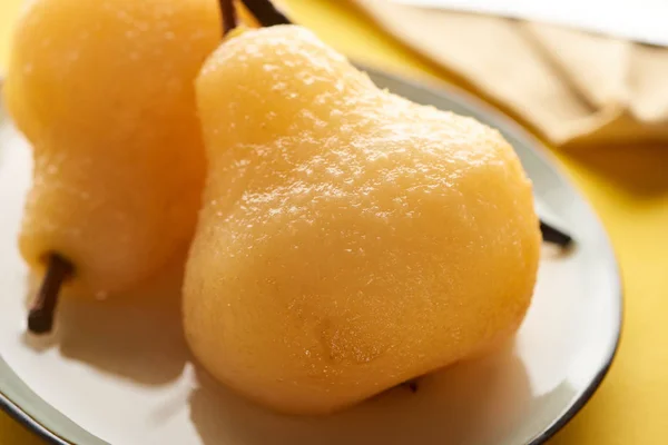 Close up view of juicy delicious pear in wine on plate — Stock Photo