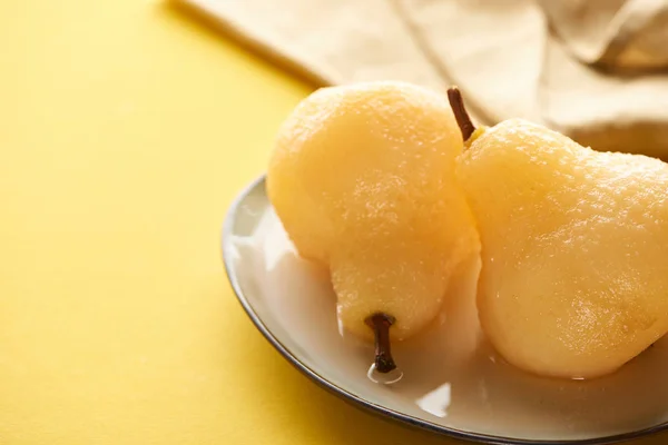 Selective focus of delicious pear in wine on plate near napkin — Stock Photo