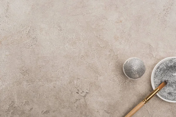 Vista superior de ovo de galinha, glitter prata com pincel na superfície de concreto cinza — Fotografia de Stock