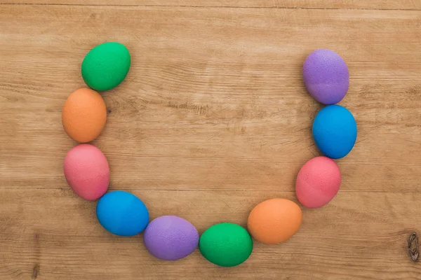 Top view of rainbow painted Easter eggs on wooden table — Stock Photo