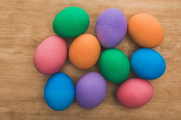 Vue du dessus des oeufs de Pâques peints à l'arc-en-ciel sur une table en bois — Photo de stock