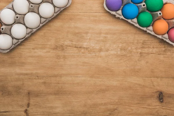 Vista superior de los huevos de Pascua pintados arco iris en la mesa de madera - foto de stock
