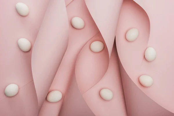 Top view of chicken eggs in spiral paper pink swirls — Stock Photo