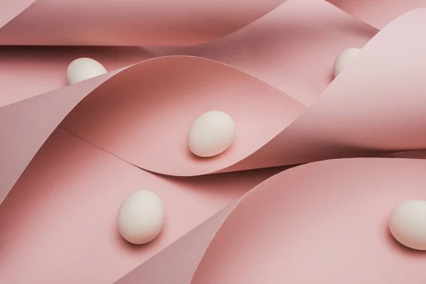 Ovos de galinha em espiral de papel rosa redemoinhos — Fotografia de Stock