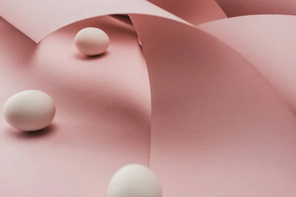 Fuoco selettivo di uova di pollo in vortici rosa carta a spirale — Foto stock