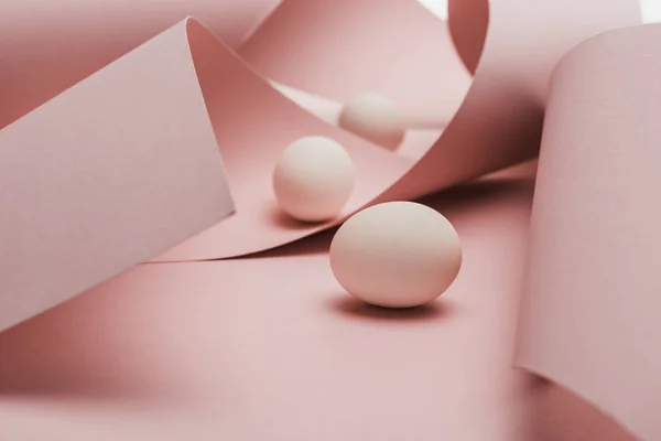 Chicken eggs in spiral paper pink swirls — Stock Photo