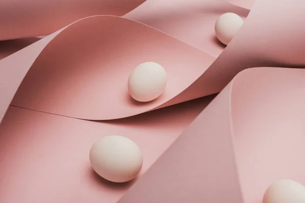 Chicken eggs in spiral paper pink swirls — Stock Photo