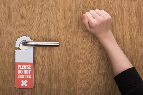 Ausgeschnittene Ansicht von Frau, die mit Bitte kein störendes Schild an Tür klopft — Stockfoto