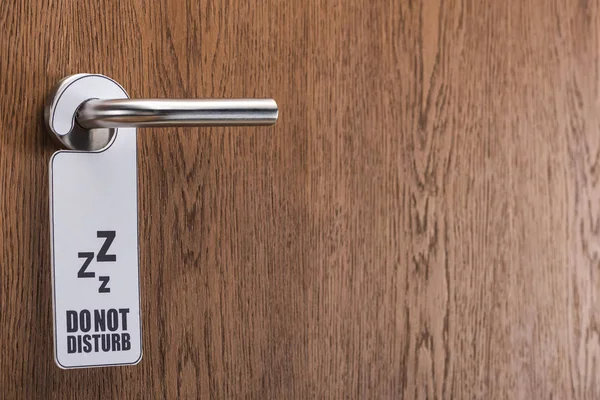 Деревянная дверь гостиничного номера с не беспокоить знак на ручке — стоковое фото