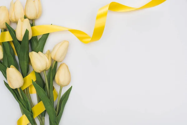 Top view of tulips and yellow ribbon isolated on white — Stock Photo