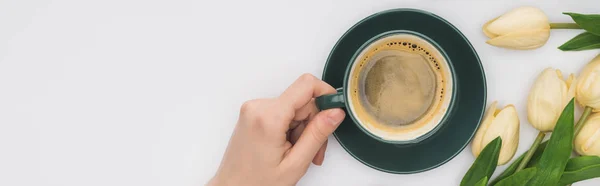 Vue recadrée de la femme tenant une tasse de café frais près des tulipes isolées sur blanc, panoramique — Photo de stock