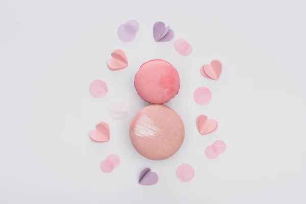 Top view of pink macarons and violet hearts isolated on white — Stock Photo