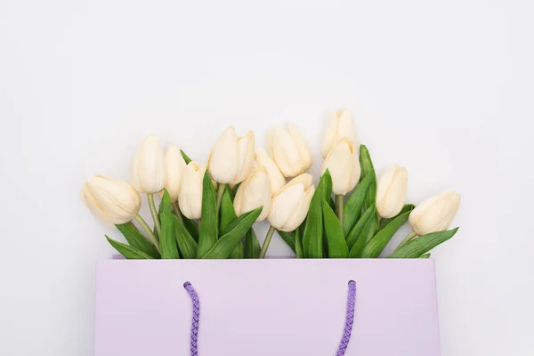 Vista superior de tulipas em saco de compras violeta isolado em branco — Fotografia de Stock