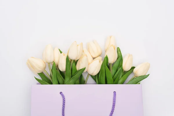 Ansicht von Tulpen in violetter Einkaufstasche isoliert auf weiß — Stockfoto