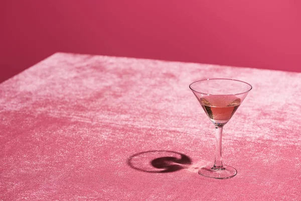 Bebida alcoólica em vidro em veludo pano rosa isolado em rosa, conceito feminino — Fotografia de Stock