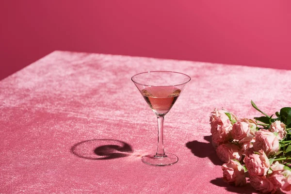 Vin rose en verre près du bouquet sur tissu velours rose isolé sur rose, concept girlish — Photo de stock