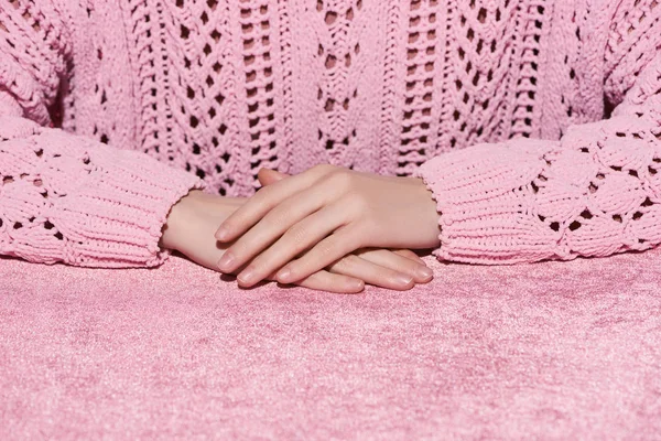 Vista recortada de la mujer con las manos apretadas en tela de terciopelo rosa, concepto de niña - foto de stock