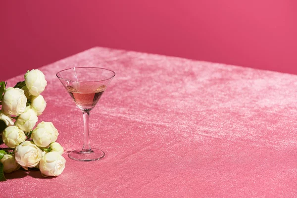 Rosenwein im Glas in der Nähe von Bouquet auf Velours rosa Tuch isoliert auf rosa, mädchenhaftes Konzept — Stockfoto