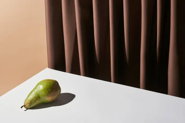 Класичне натюрморт з грушею на столі біля завіси ізольовано на бежевому — стокове фото