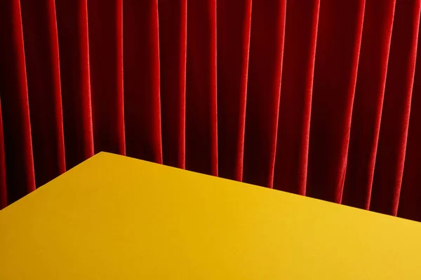 Fondo con mesa amarilla cerca de la cortina roja - foto de stock
