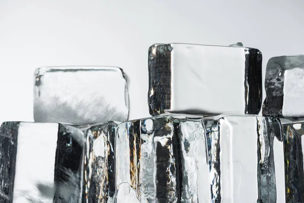 Vista de perto de derreter cubos de gelo quadrados transparentes isolados em branco — Fotografia de Stock