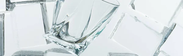 Vista superior de cubos de gelo quadrados transparentes e vidro vazio no espelho, tiro panorâmico — Fotografia de Stock