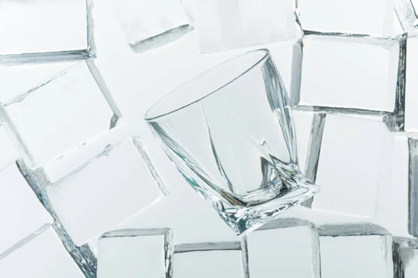 Top view of transparent clear square ice cubes and empty glass on mirror — Stock Photo