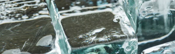 Close up view of melting transparent clear square ice cubes, panoramic shot — Stock Photo