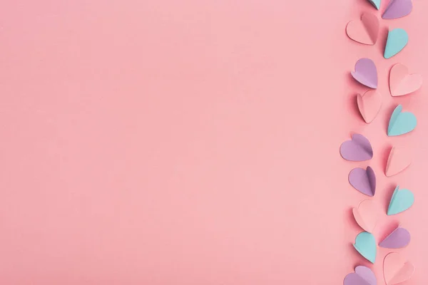 Draufsicht auf bunte Papierherzen auf rosa Hintergrund — Stockfoto