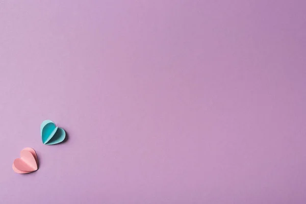 Vista dall'alto di cuori di carta colorati su sfondo viola — Foto stock